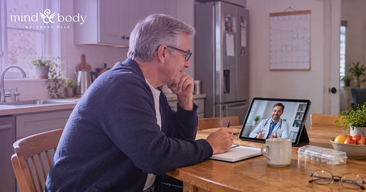 Person holding a glass of water and a pill organizer at a kitchen table in the morning